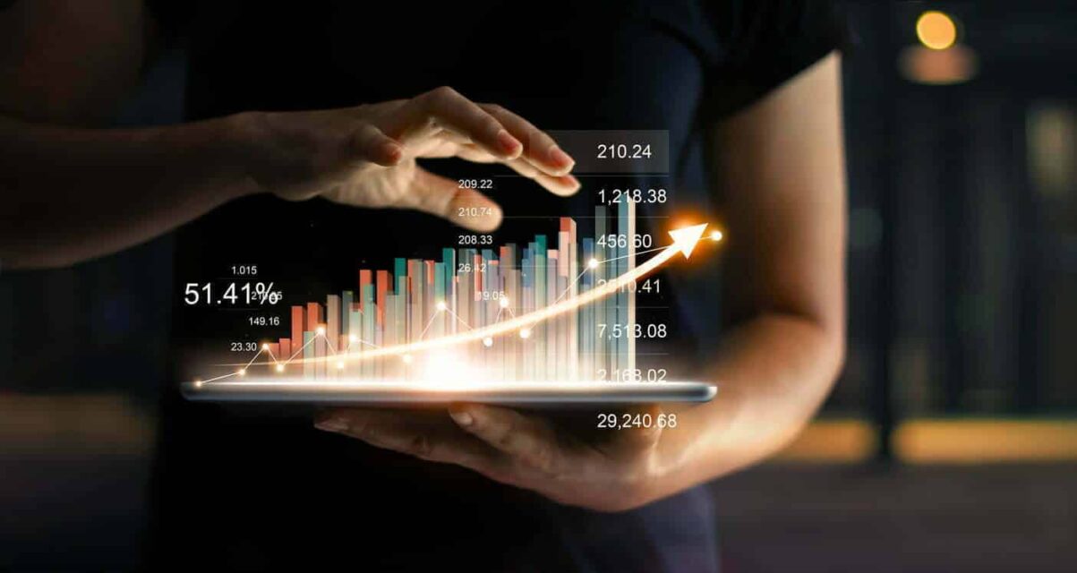 Businessman holding tablet and showing a growing virtual hologram of statistics, graph and chart with arrow up on dark background. Business growth, planing and strategy concept.