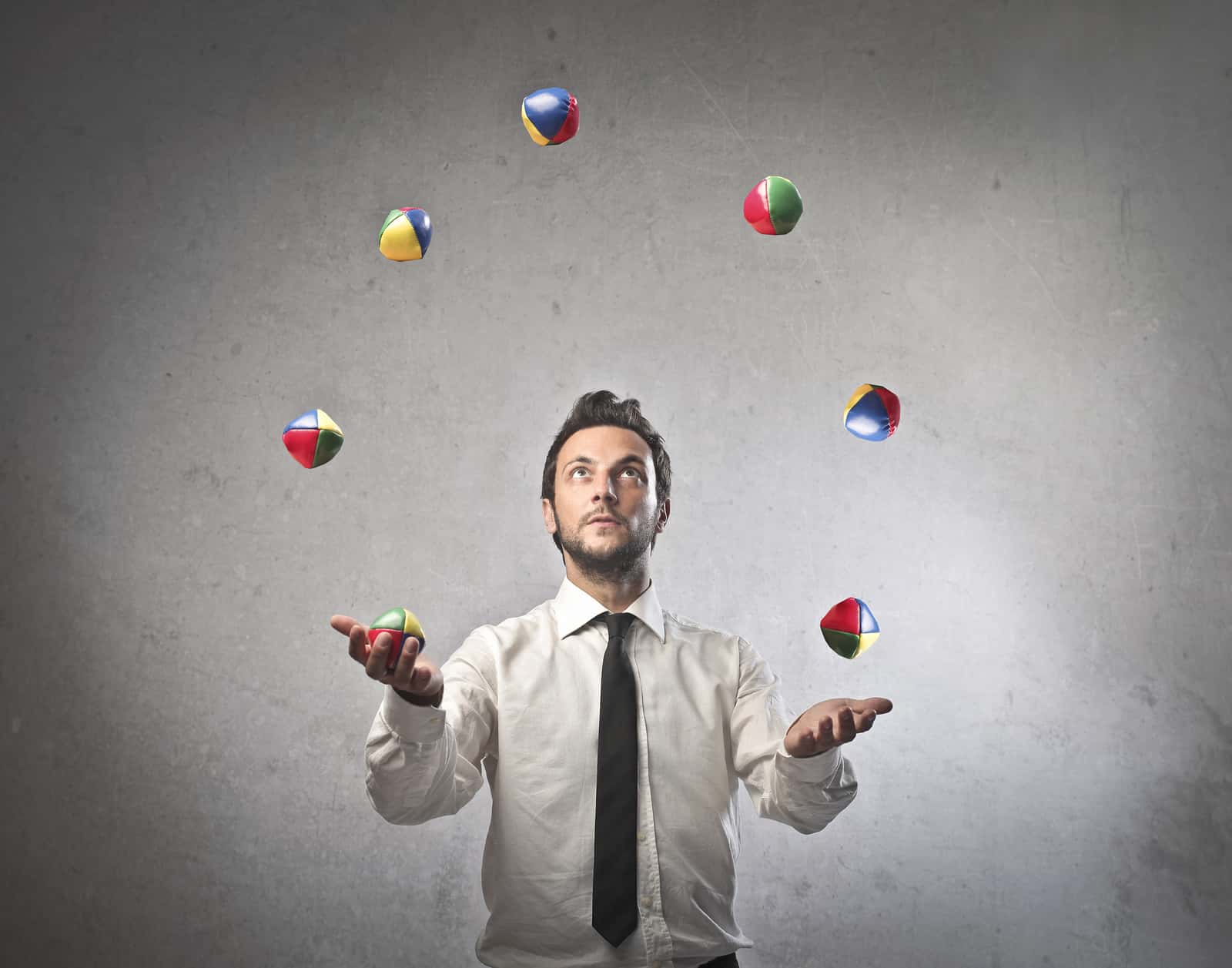 person juggling balls in a shirt and tie