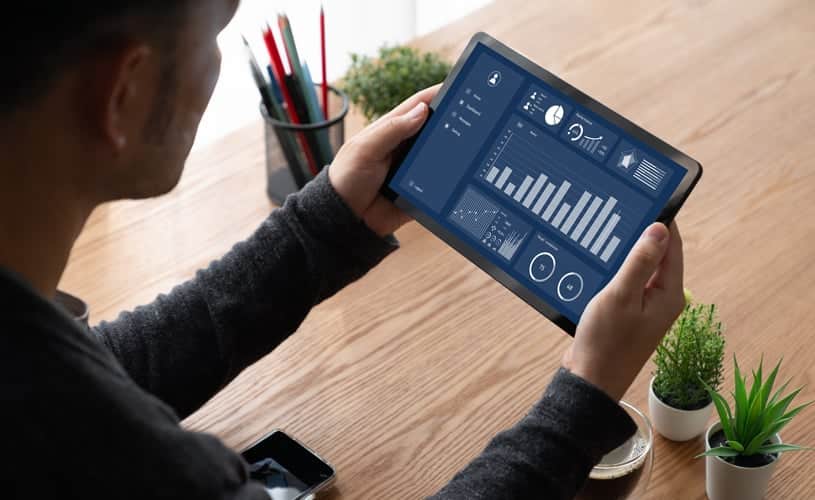 man holding a tablet with data showing a data governance dashboard