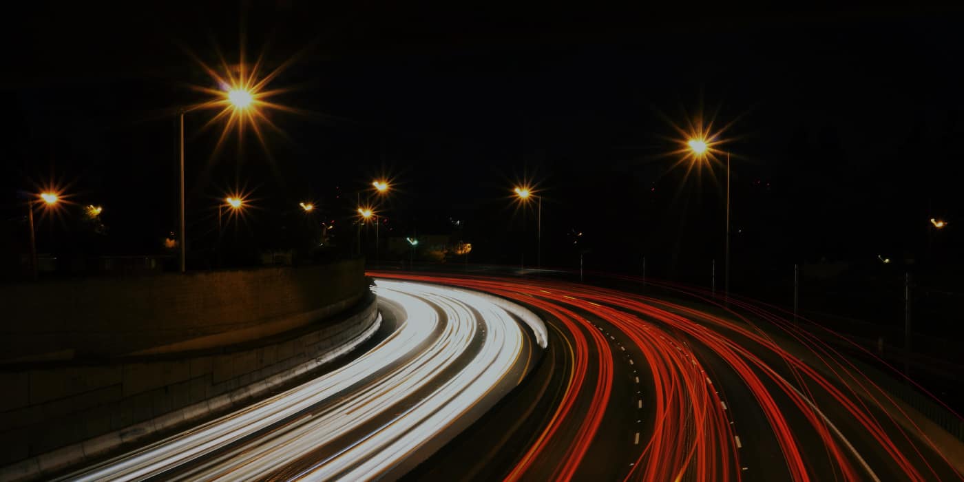 long exposure photo of cars driving at night and their light streaks