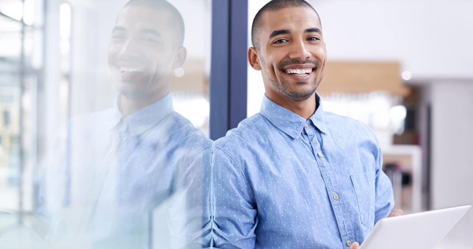 Man with a laptop smiling, possibly learning about ACID transactions