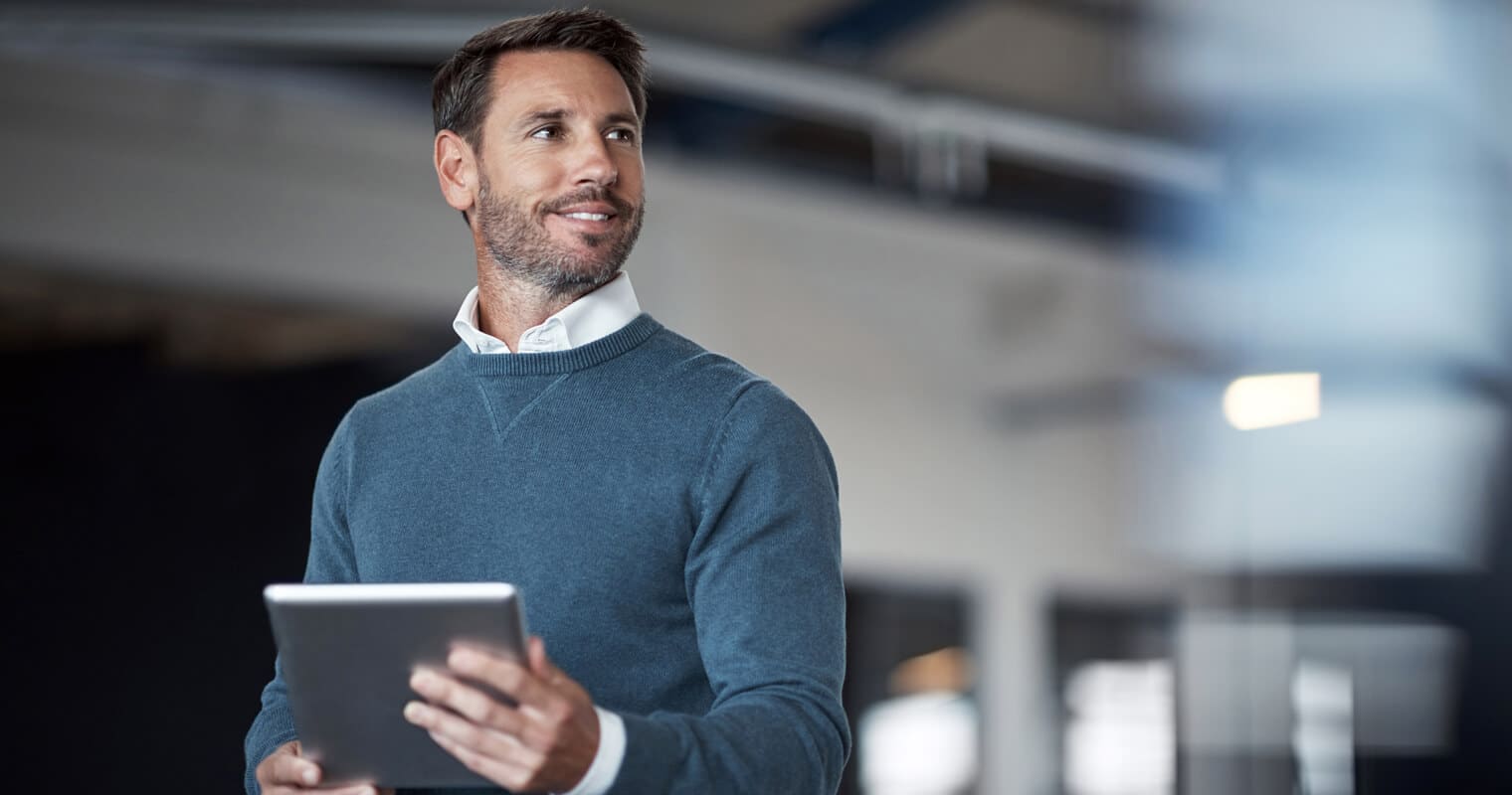 Selbstbewusster Geschäftsmann mit Tablet, der Datenworkflows in einem modernen Büro verwaltet.